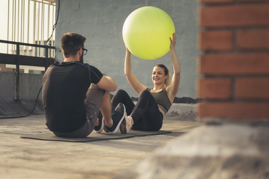 Couple training with a pilates ball